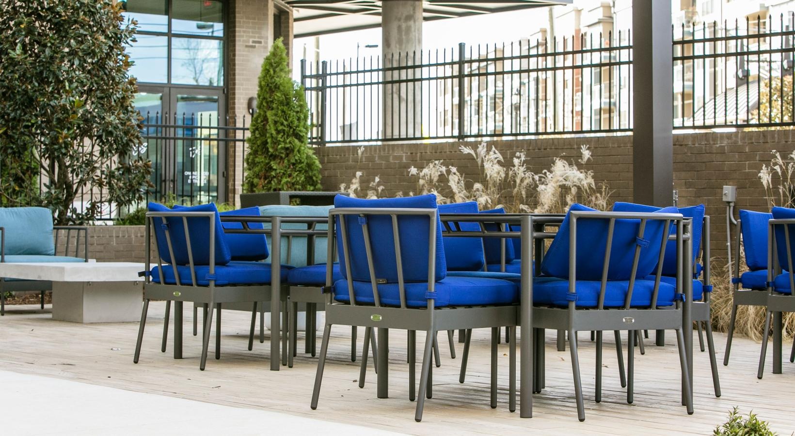 Settle into comfort at Bradham at New Bern a group of blue chairs outside