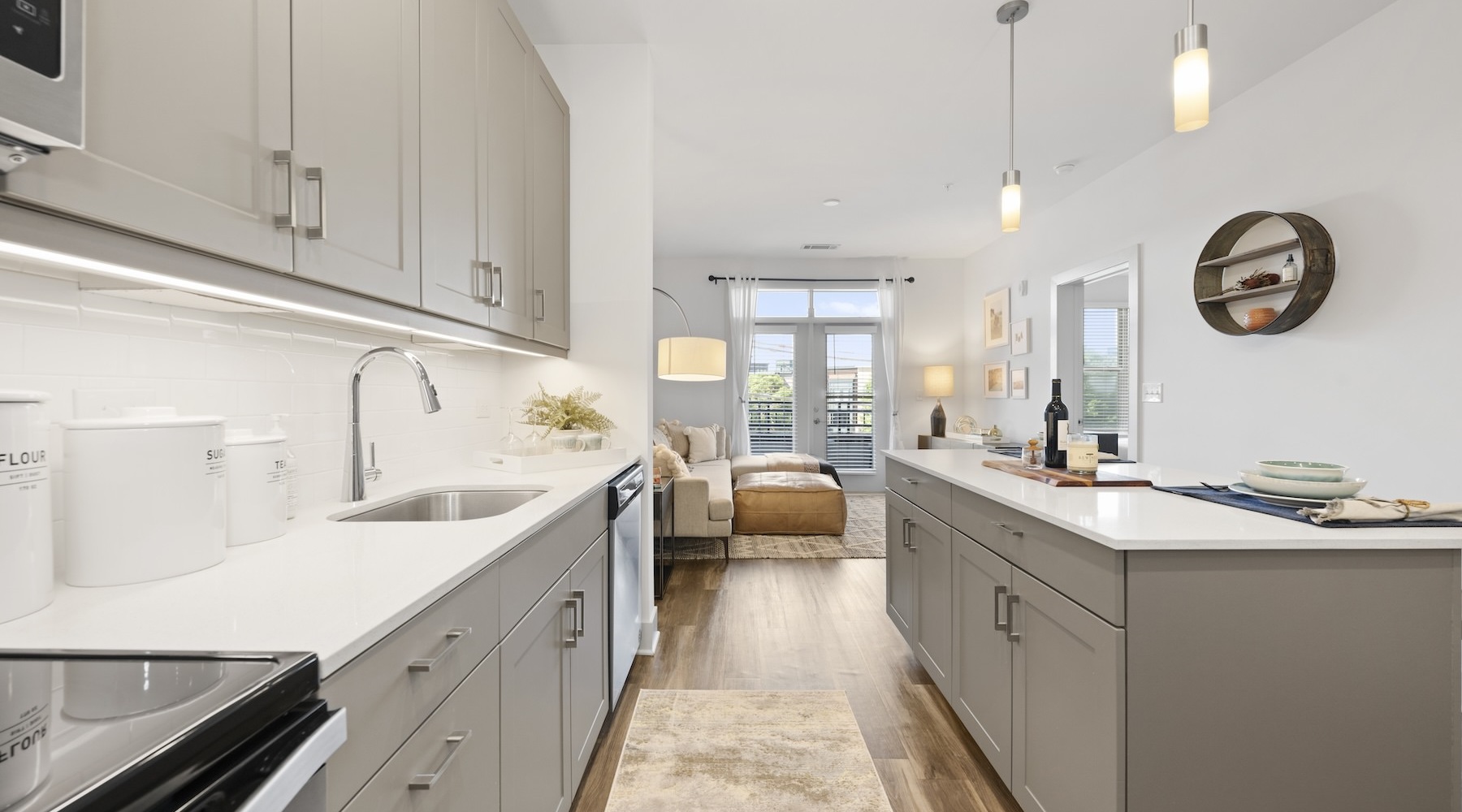 Luxury kitchen with gray cabinetry, stainless steel appliances, and white countertops in Charlotte apartments for rent at Bradham at New Bern.