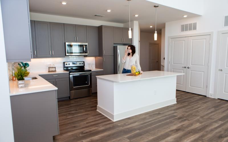 Person standing in luxury kitchen at Bradham at New Bern apartments in Charlotte