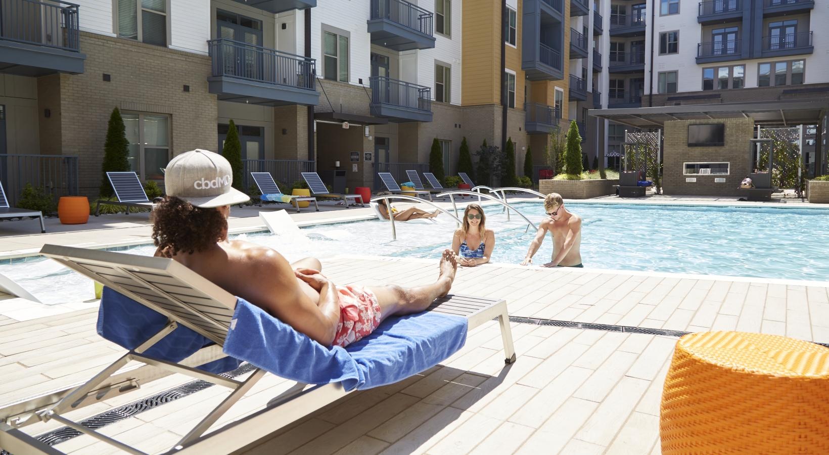 Shimmering resort-style pool a group of people sitting around a pool